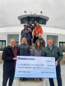 Argosy Office Staff, CEO Kevin Clark, and Alan Fisco, President of the Seattle Time, onboard the Salish Explorer with a donation check.