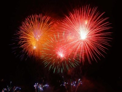 4th of July Cruises: Brilliant red fireworks illuminate the night, perfect for 4th of July celebrations.